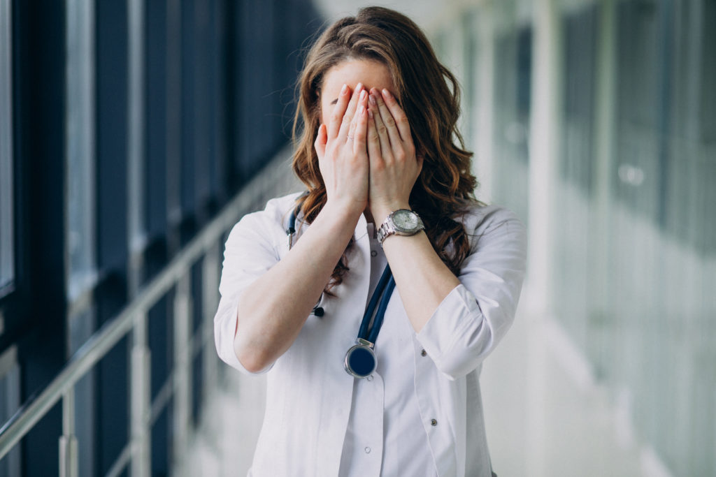 joven doctora con estetoscopio en el hospital scaled